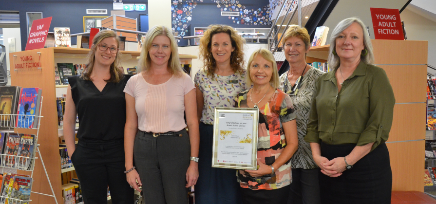 Mrs Gill Martin holds an award with other Teacher Librarians